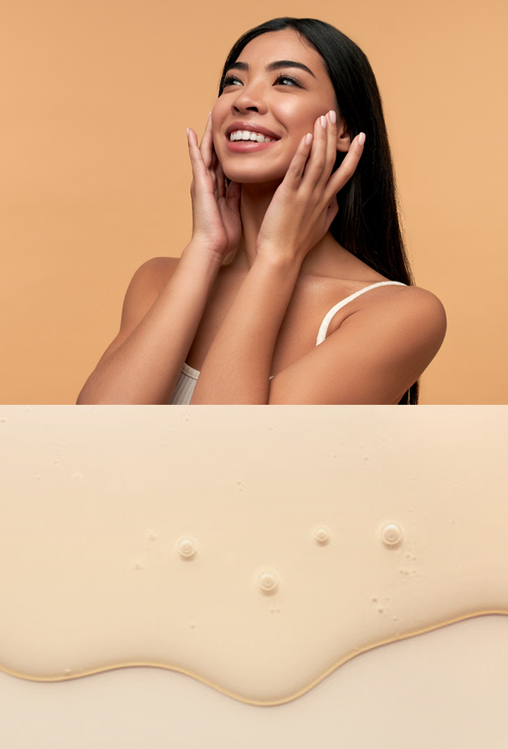 Happy woman with glowing skin touching her face, above flowing beige liquid with bubbles.